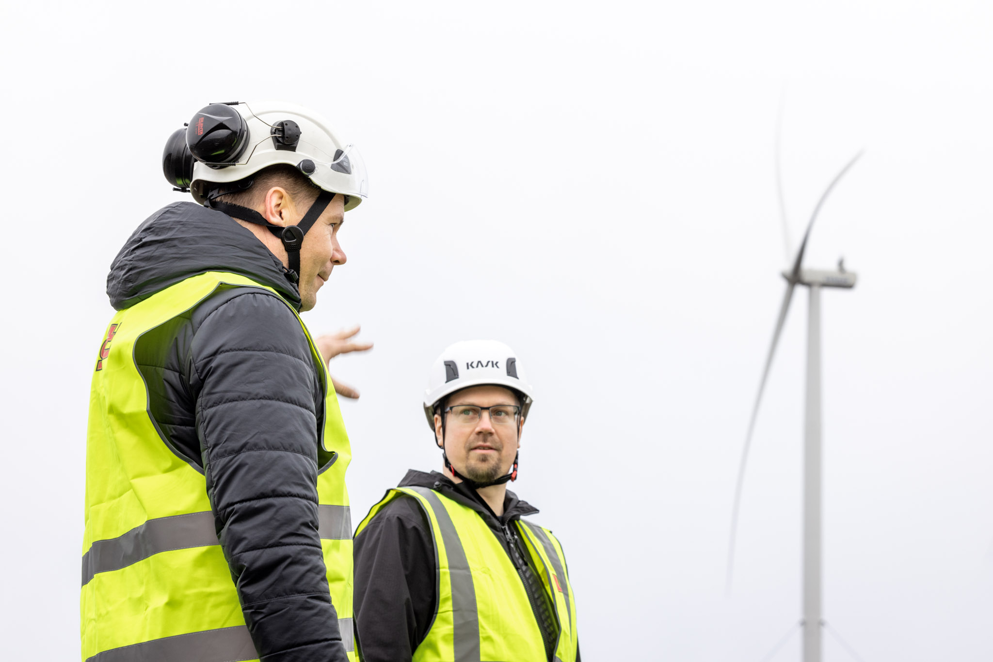 Two men next to wind turbine